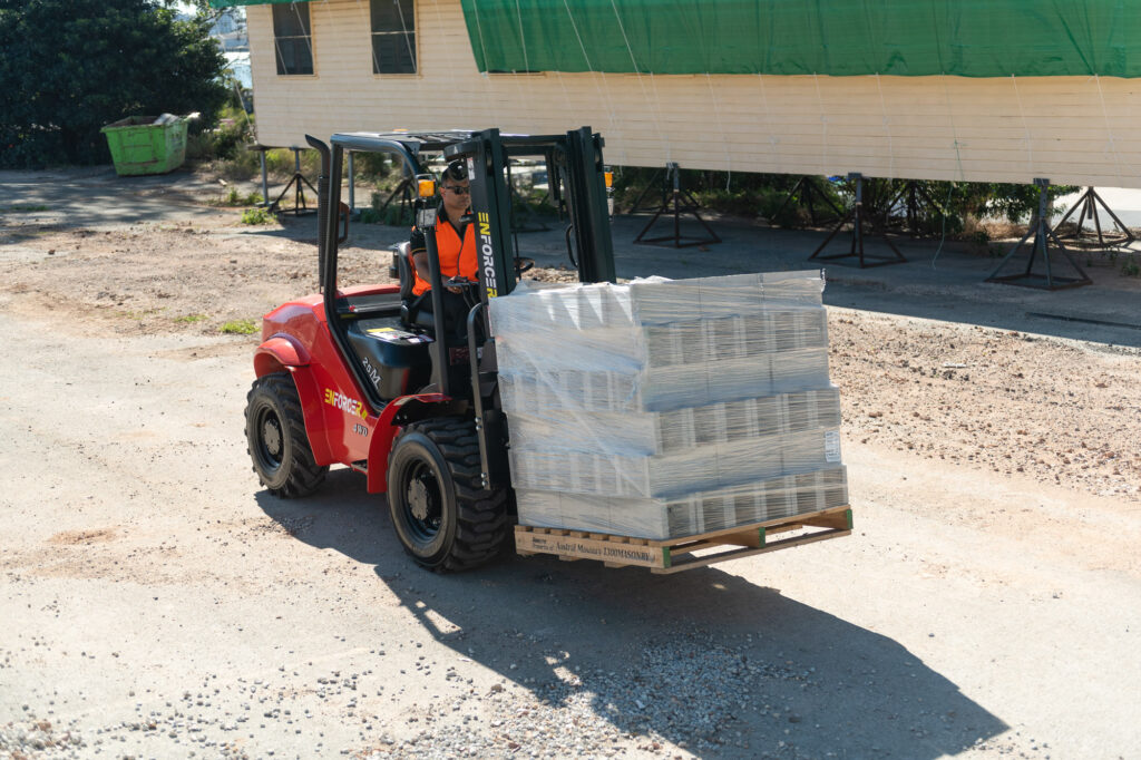 Enforcer Rough Terrain Forklift Lifting Pallets in Outdoor Yard